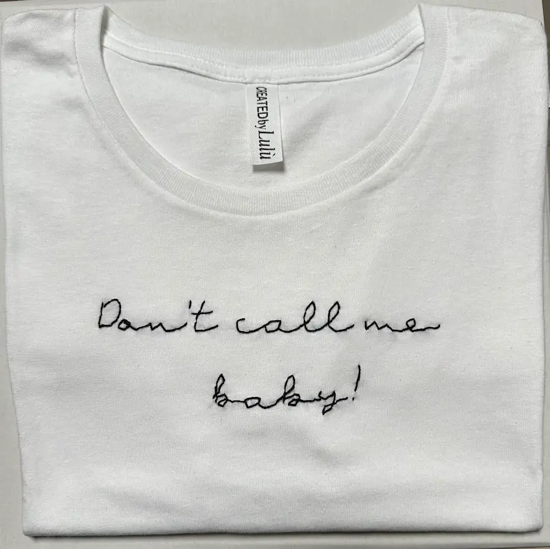 T-shirt bianca 100% cotone con scritta ricamata a mano “don't call me baby"